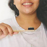 A person holding Natural Bamboo Toothbrush with Activated Charcoal Bristles