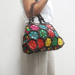 Model holding Multi colour 'Dahlia' coconut handbag