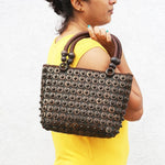 Model holding DaisyLife coconut bags as natural fashion. A beautiful accessory to add to your outfit.