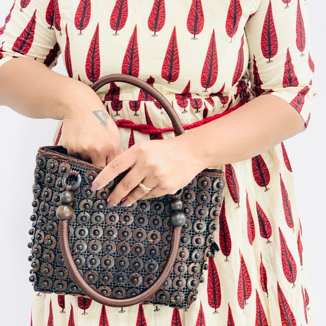 Model holding DaisyLife coconut bags as natural fashion. A beautiful accessory to add to your outfit.