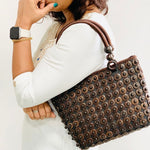 Model holding DaisyLife coconut bags as natural fashion. A beautiful accessory to add to your outfit.