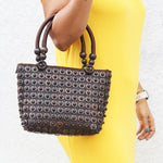 Model holding DaisyLife coconut bags as natural fashion. A beautiful accessory to add to your outfit.