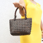 Model holding DaisyLife coconut bags as natural fashion. A beautiful accessory to add to your outfit.