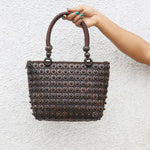 Model holding DaisyLife coconut bags as natural fashion. A beautiful accessory to add to your outfit.