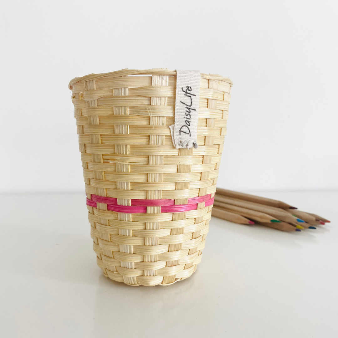 Natural bamboo cup with pink strip with pencils in back