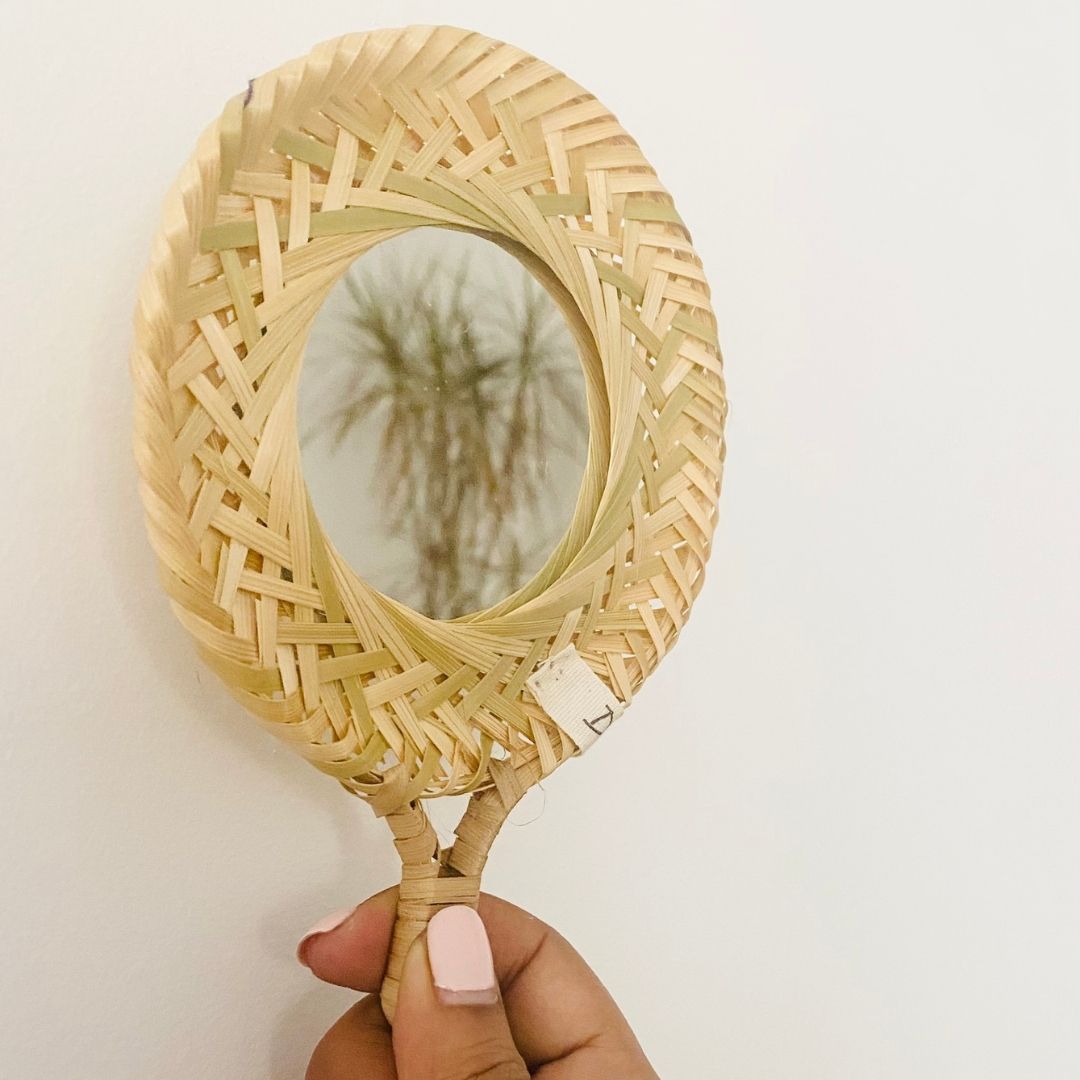 Handcrafted bamboo mirror reflecting plant