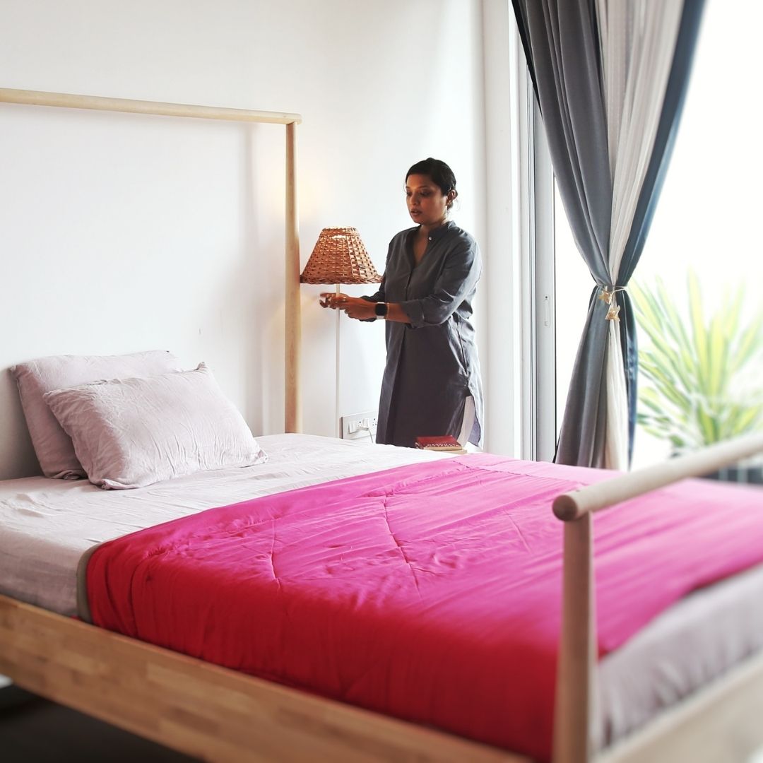 A women standing with Handwoven Lampshade placed in bedroom setting.