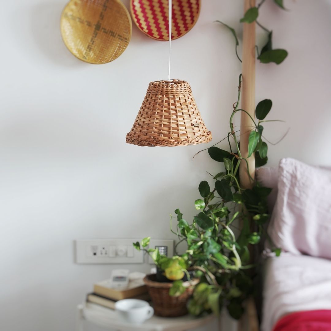 Wicker handwoven lampshade with plant in background for bedroom décor. 