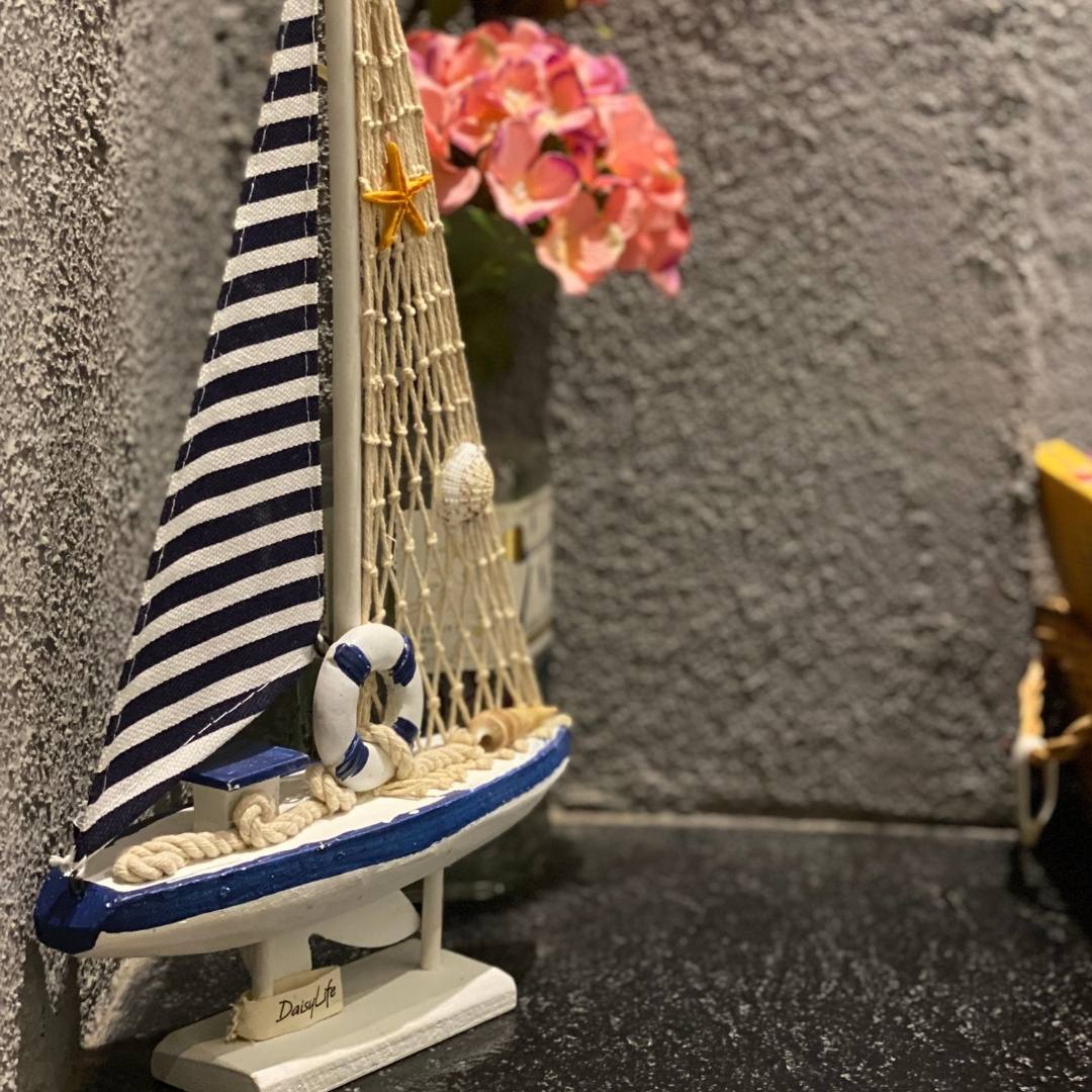 Wooden Natural coral/Seashell ship with blue flag, planter in background