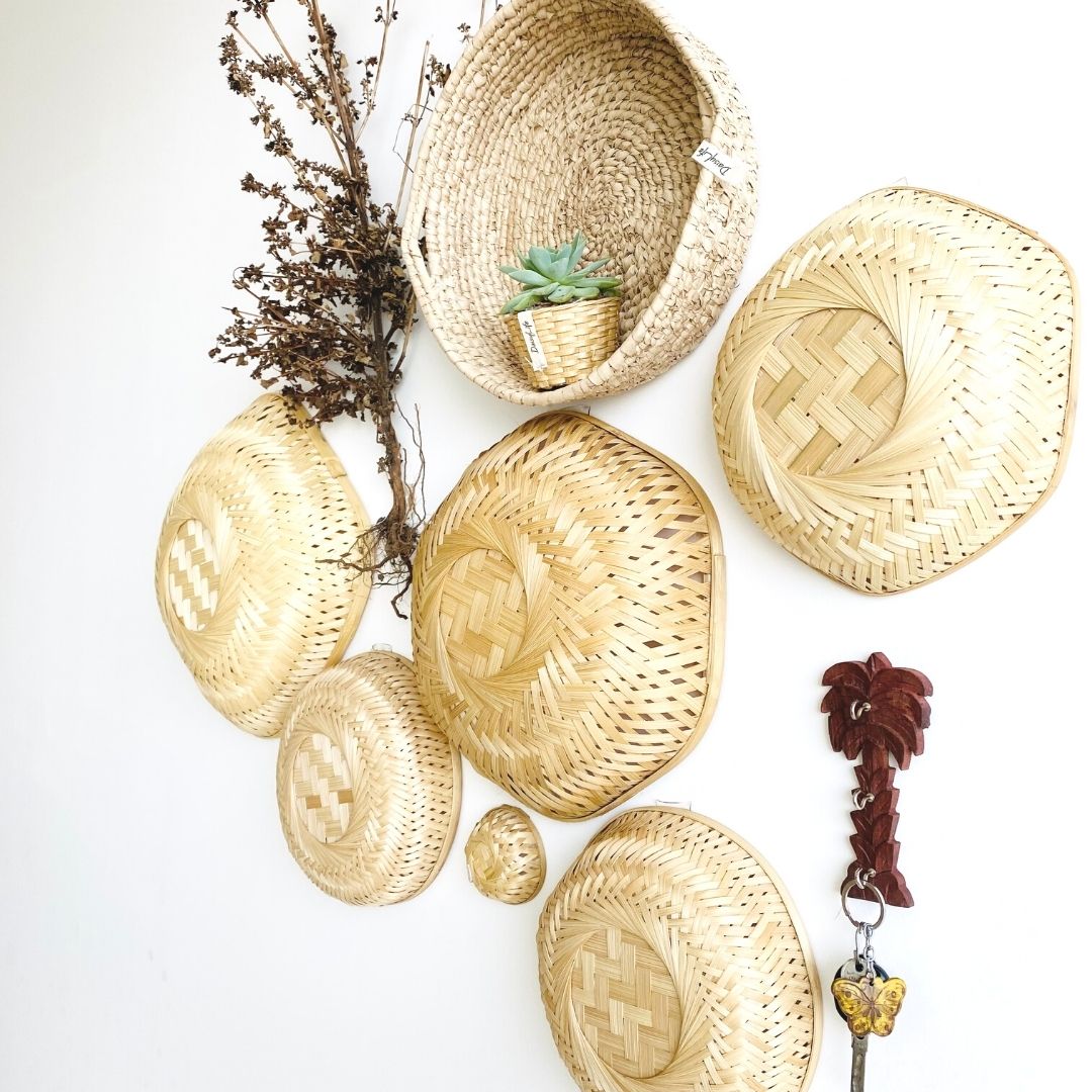 Baskets in different shapes and sizes, a little planter, a palm tree keychain hangar made with bamboo, grass and wood in this installation. 