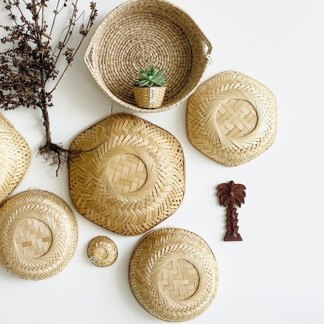 Baskets in different shapes and sizes, a little planter, a palm tree keychain hangar made with bamboo, grass and wood in this installation. 