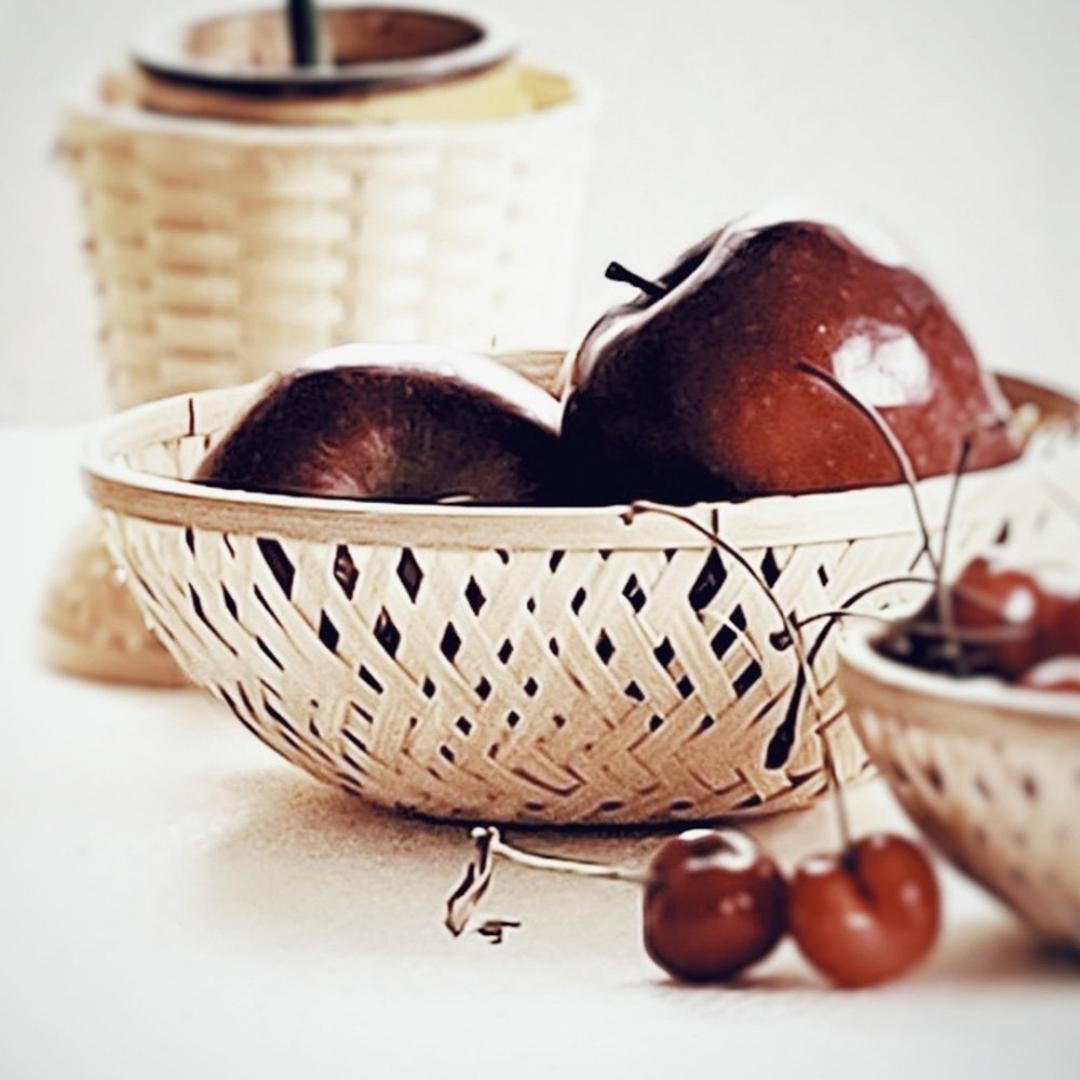 Apples kept inside Simple, round, natural multi-purpose bamboo basket