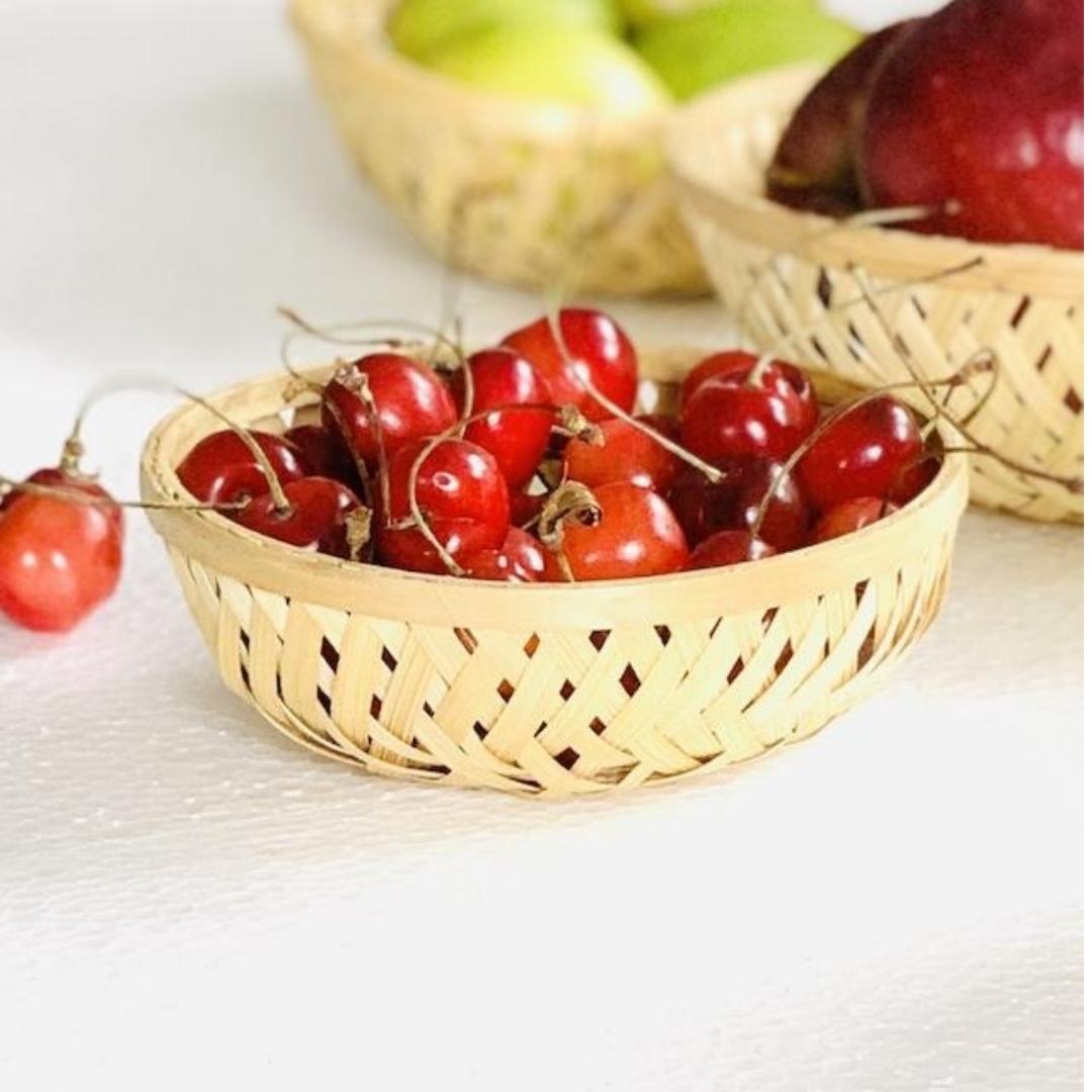 Cherries kept inside Simple, round, natural multi-purpose bamboo basket