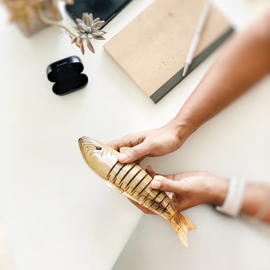 A person fidgeting with Natural and Eco-friendly Natural Wooden fish 