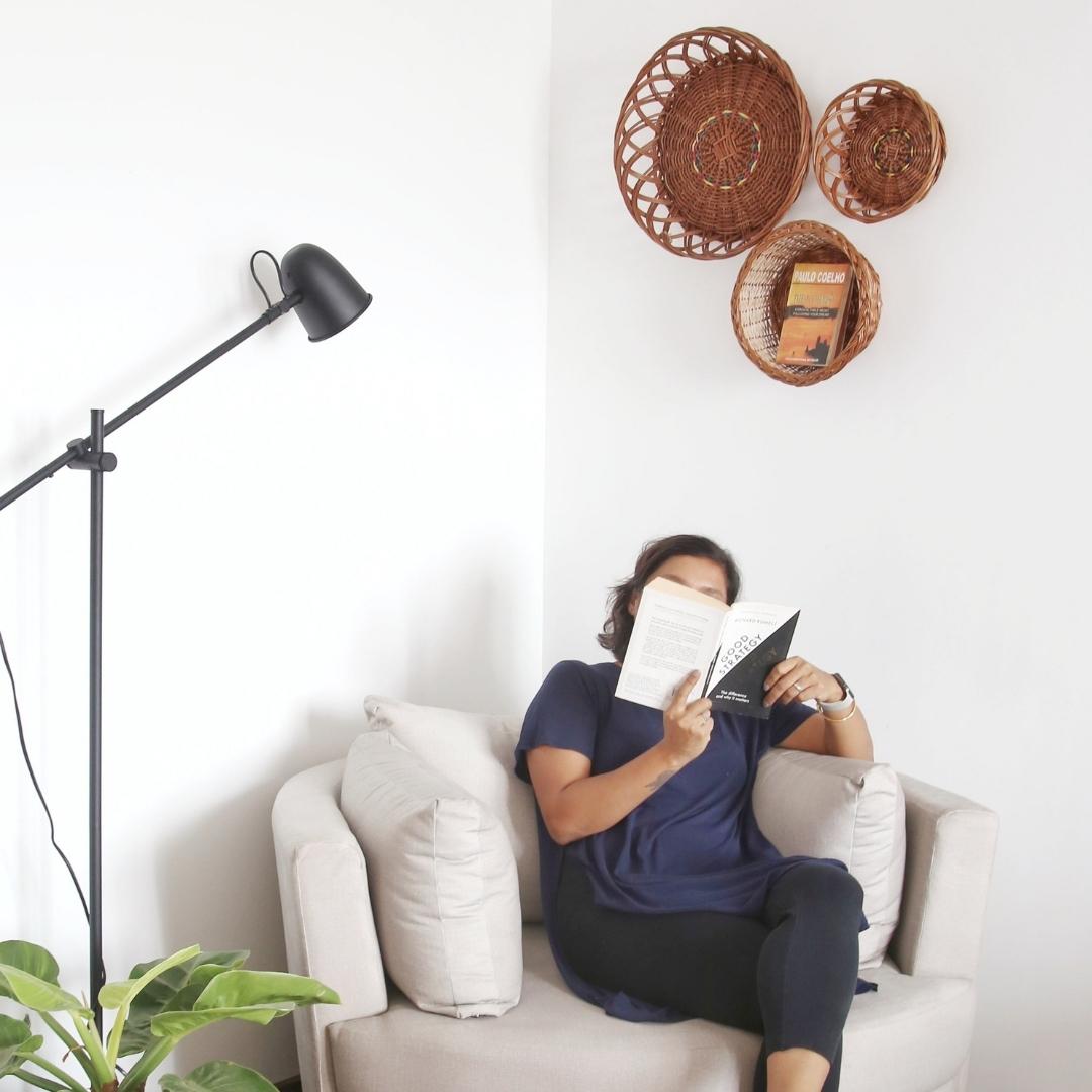A person reading book with Trio Wall Baskets for wall decor