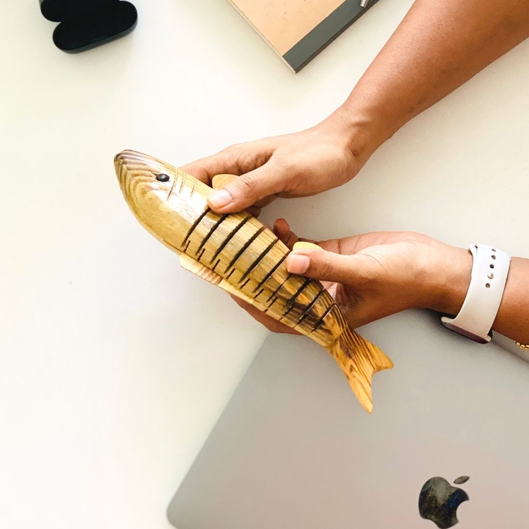 A person holding "Bubbles" Wooden Fish. 